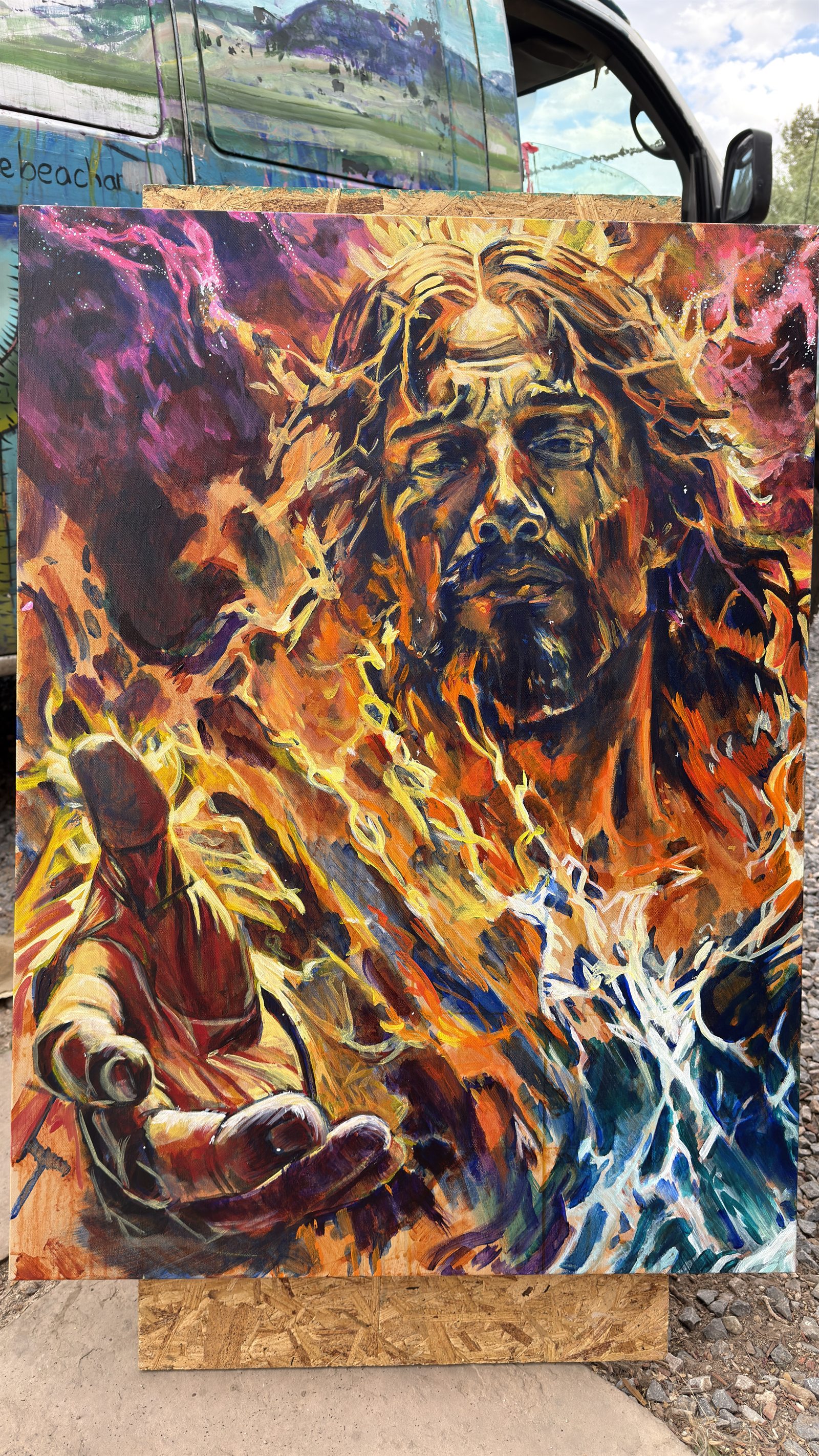 Painting of a roaring lion surrounded by fiery orange, yellow, blue, and white marks.