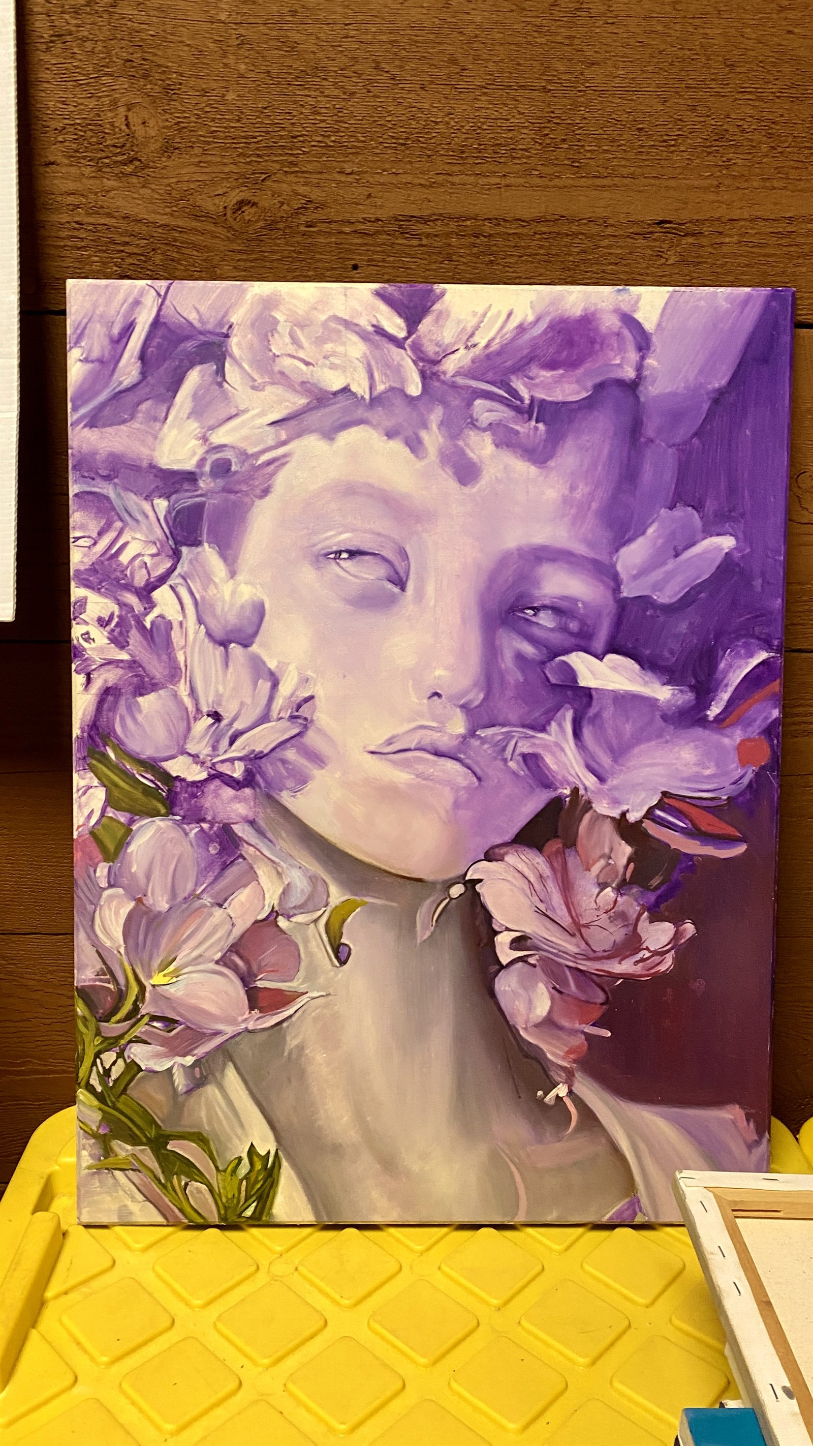 Purple-toned portrait painting of a face surrounded by floral shapes and soft highlights.
